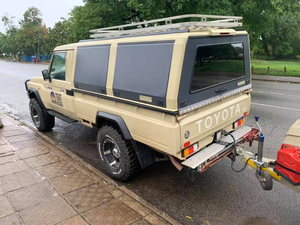 Toyota Land Cruiser 79 double cab fitted with a color-matched aluminium canopy, side-access doors, and a roof rack