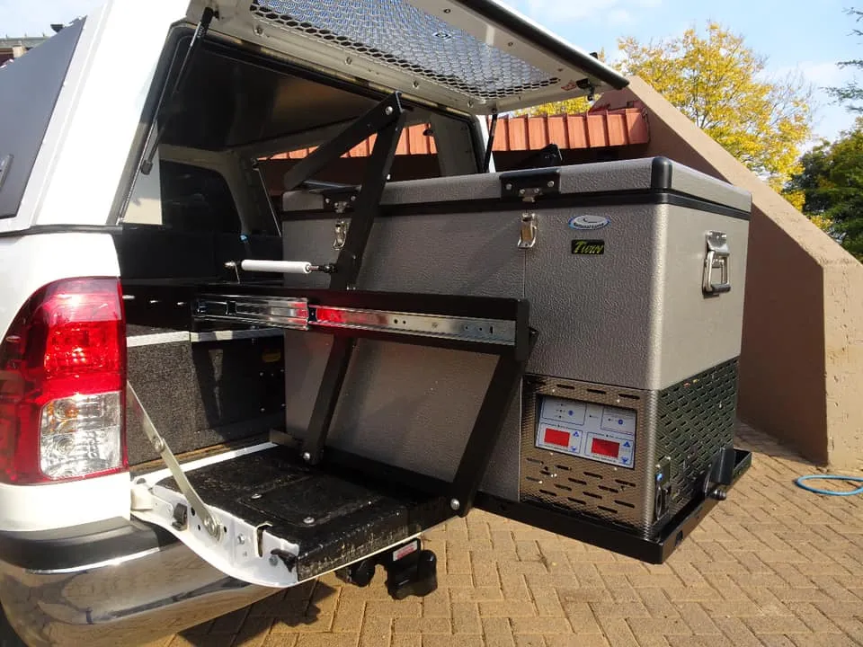 National Luna dual-zone fridge freezer mounted on a drop-down slide inside a white Toyota Hilux double cab load box