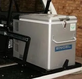 Silver Engel 12V portable fridge freezer mounted on a sliding tray system inside a vehicle cargo bay